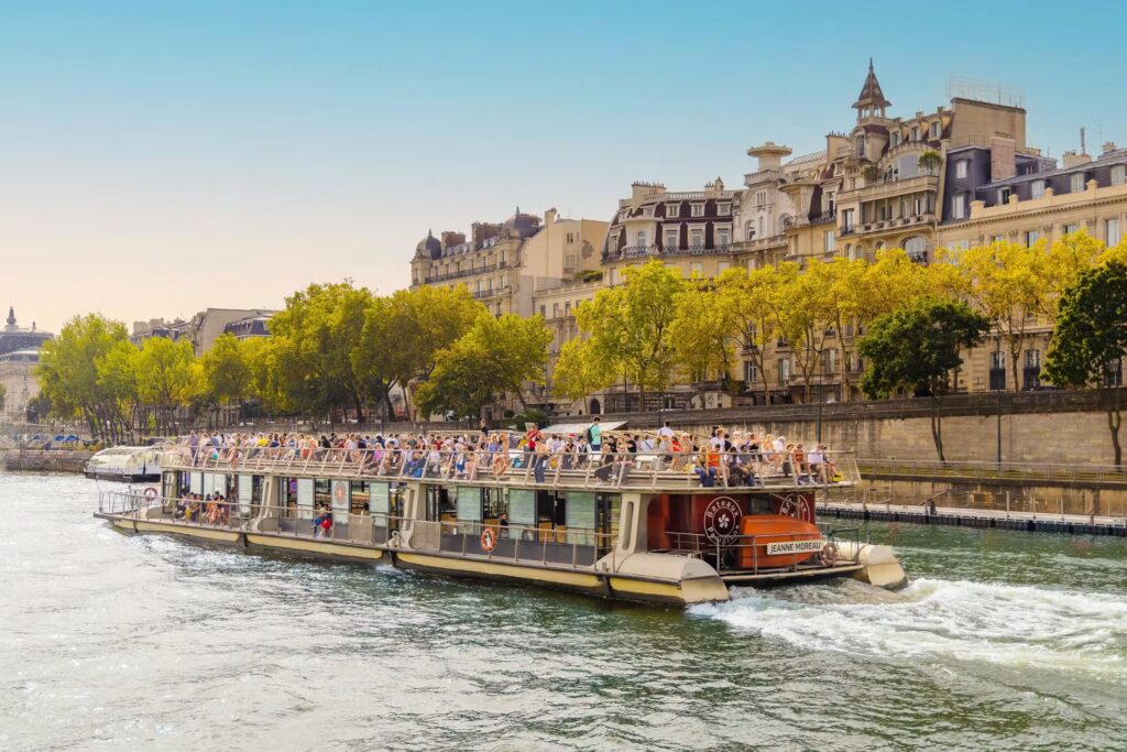 Seine-Kreuzfahrtschiff mit Menschen, die die Aussicht auf Paris genießen